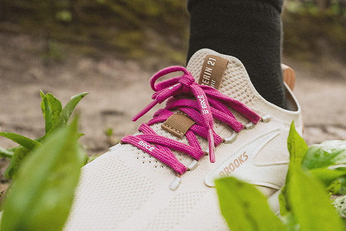 A magenta BRCE lattice-grip lace used on a white running shoe